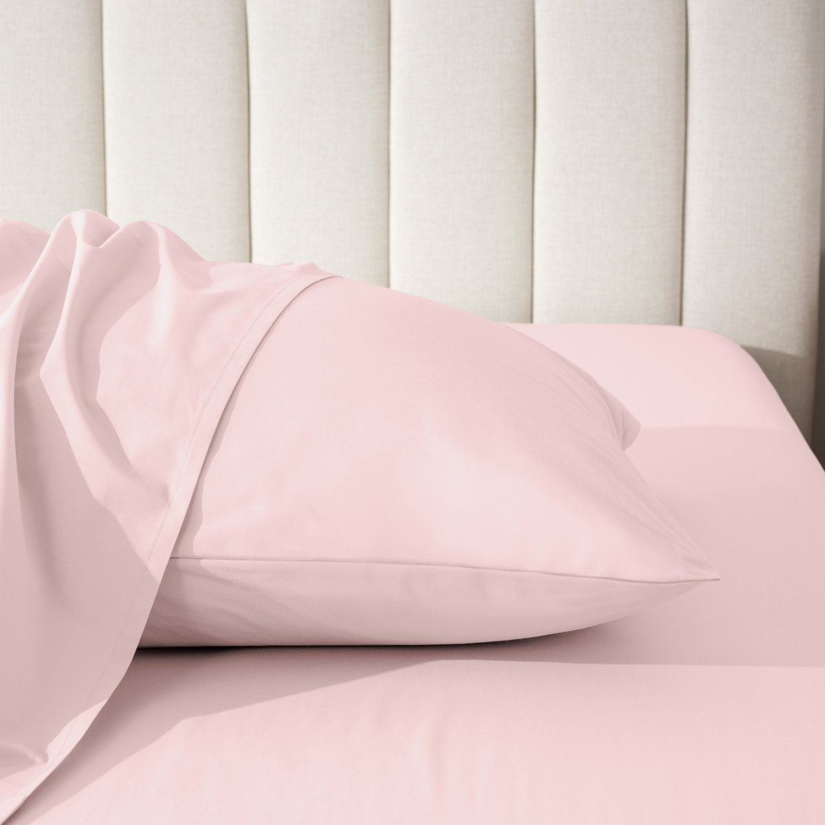 Pillow on a bed with a neutral headboard