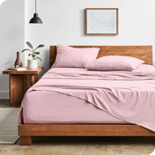 Modern bedroom with washed sheets draped over the end and the side of the bed