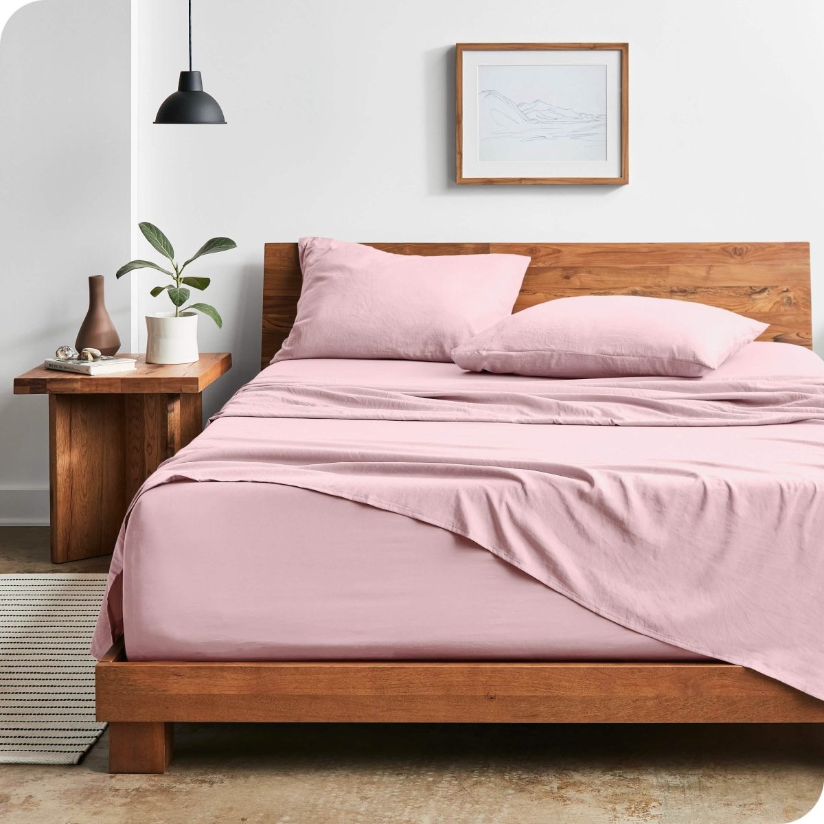 Modern bedroom with washed sheets draped over the end and the side of the bed