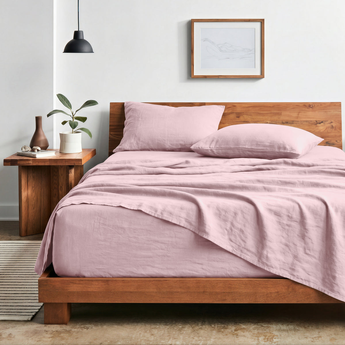 Bedroom with sheet set on a wooden bed frame and side table