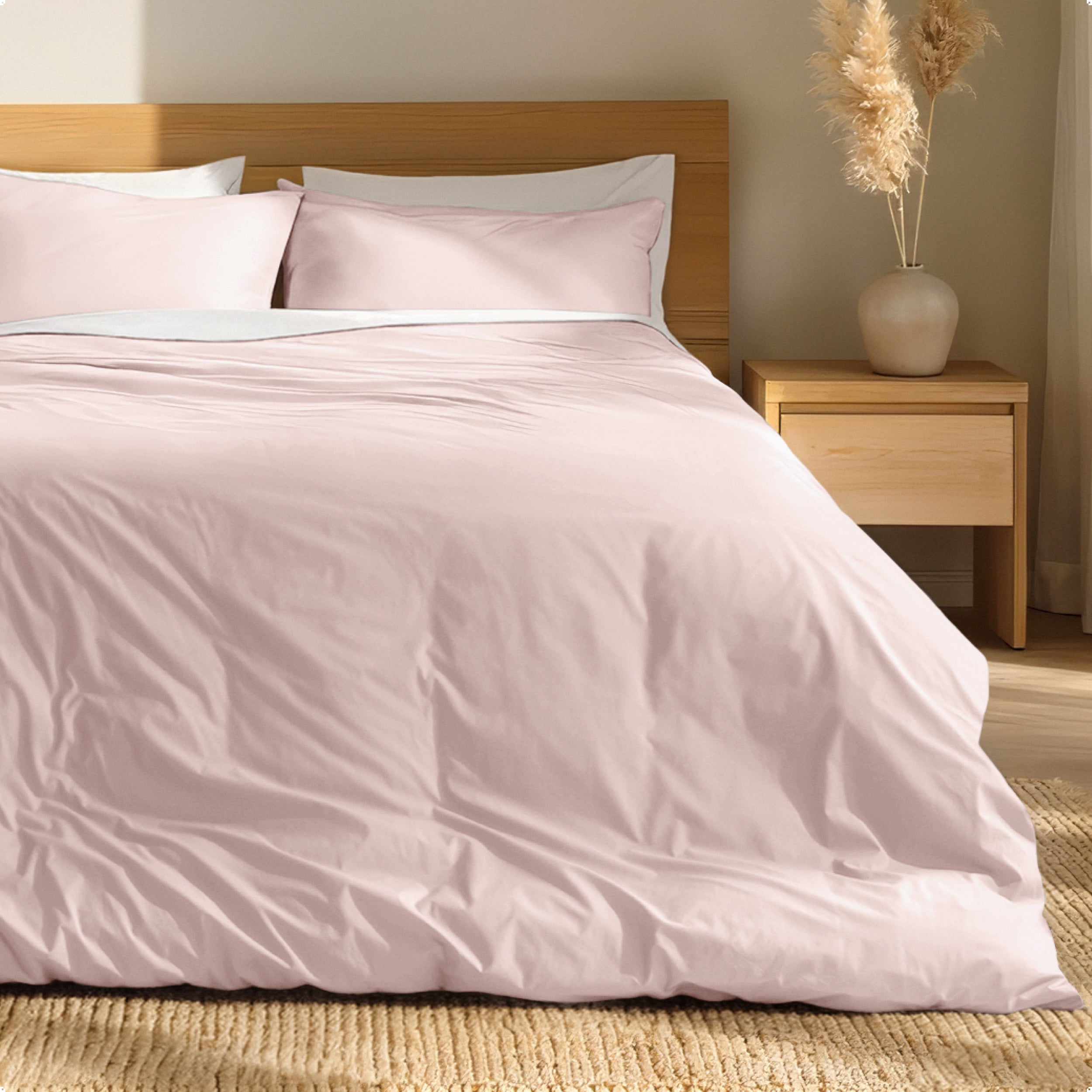 Percale bedding set on a bed with a wooden headboard and nightstand in a bedroom setting.