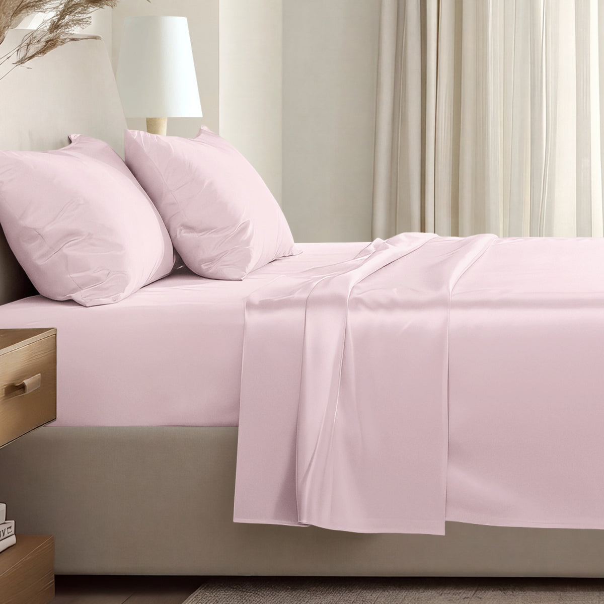 Sateen sheet set on a bed in a softly lit bedroom.