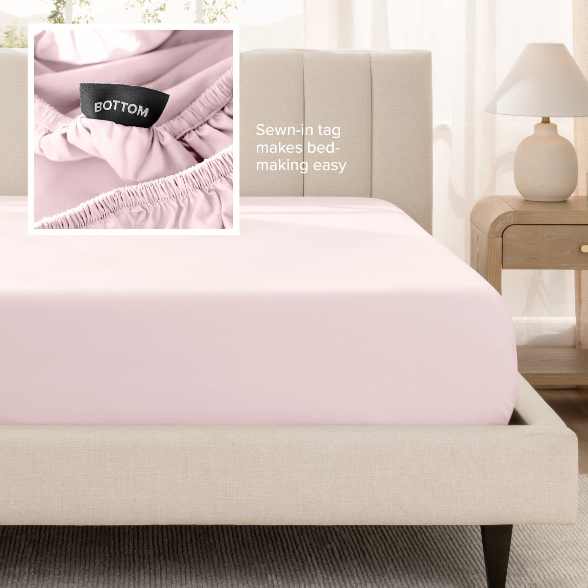 A fitted bed sheet shown on a bed. Text on the image says the sewn-in tag makes bed-making easy.
