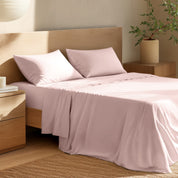 Bed with percale bedding and wooden headboard in a bedroom setting