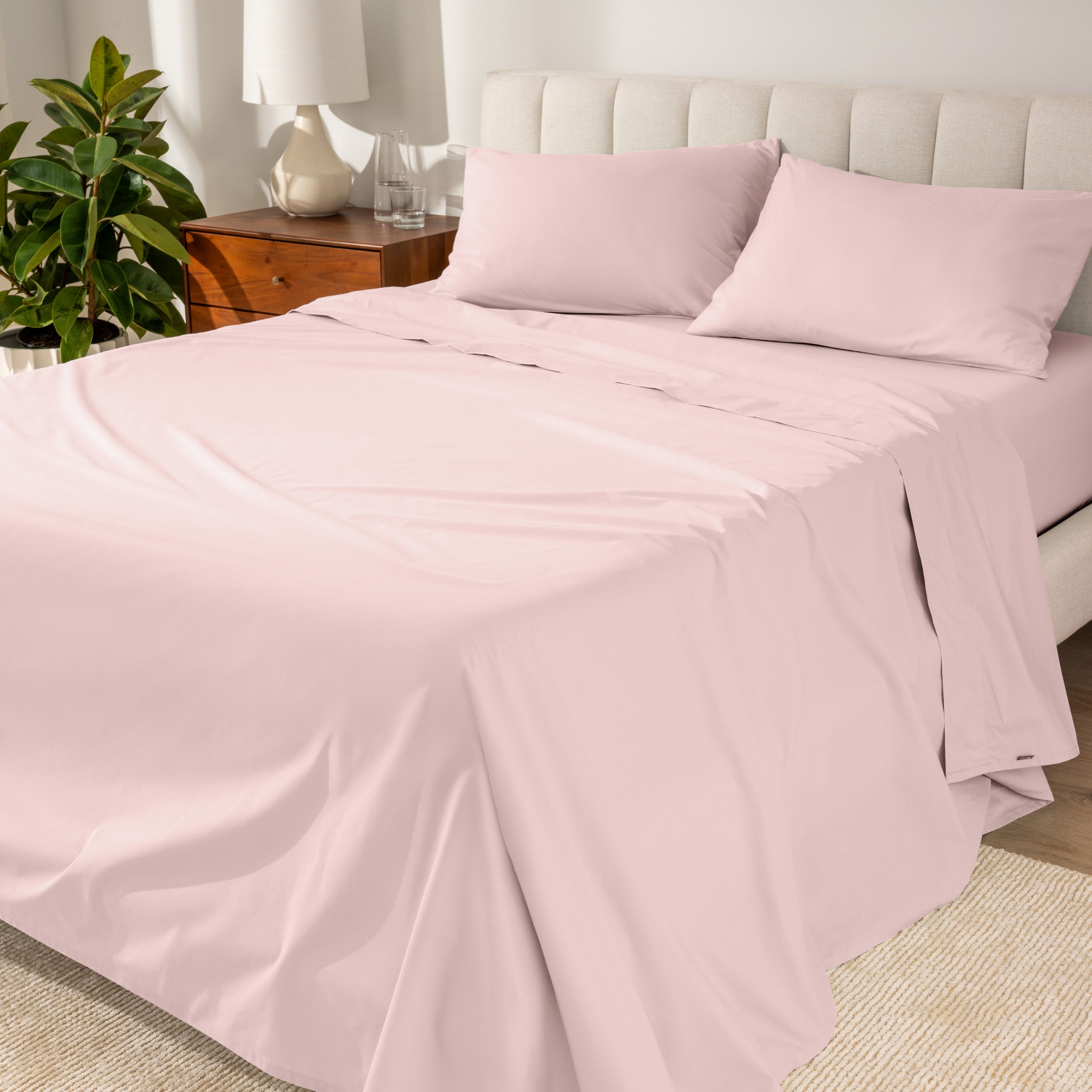 Percale sheets on a bed with a cream colored frame and headboard