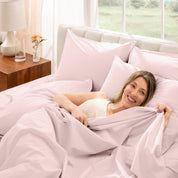 Woman lying in bed with percale bedding in a bright bedroom