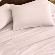 Close up of percale pillowcases and sheets on a bed