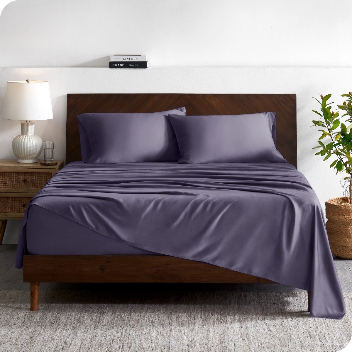 A contemporary bed with a sheet set and a wooden headboard.