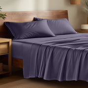 Bamboo bed sheets on a bed in a bedroom with night stands.