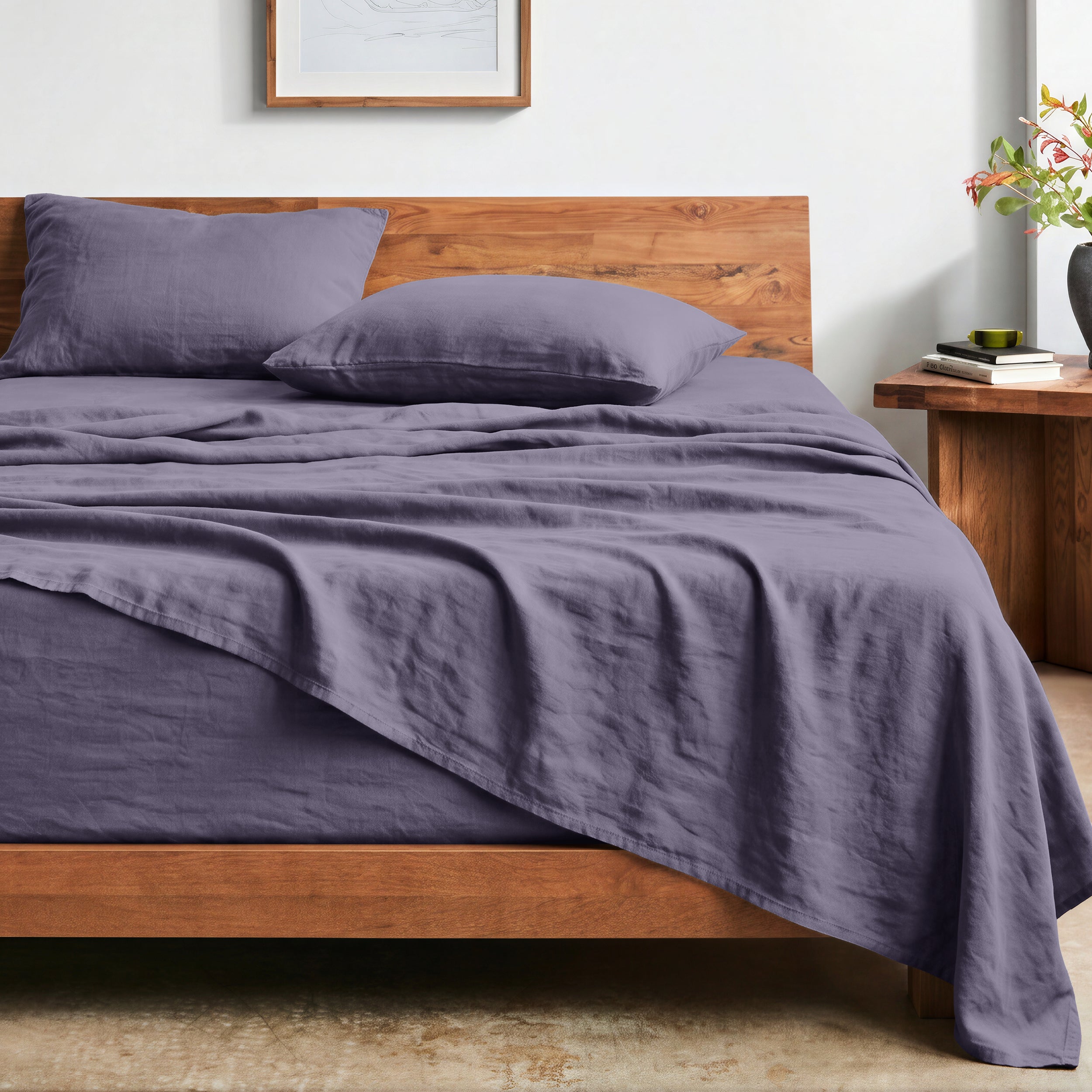 Bed with washed sheets and wooden headboard in a bedroom setting