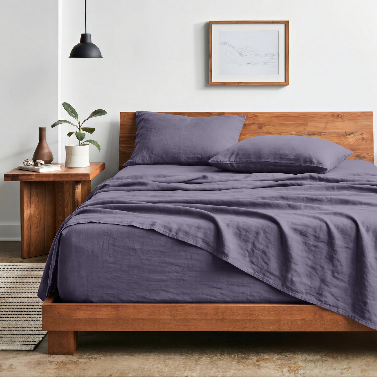 Bedroom with sheet set on a wooden bed frame and side table
