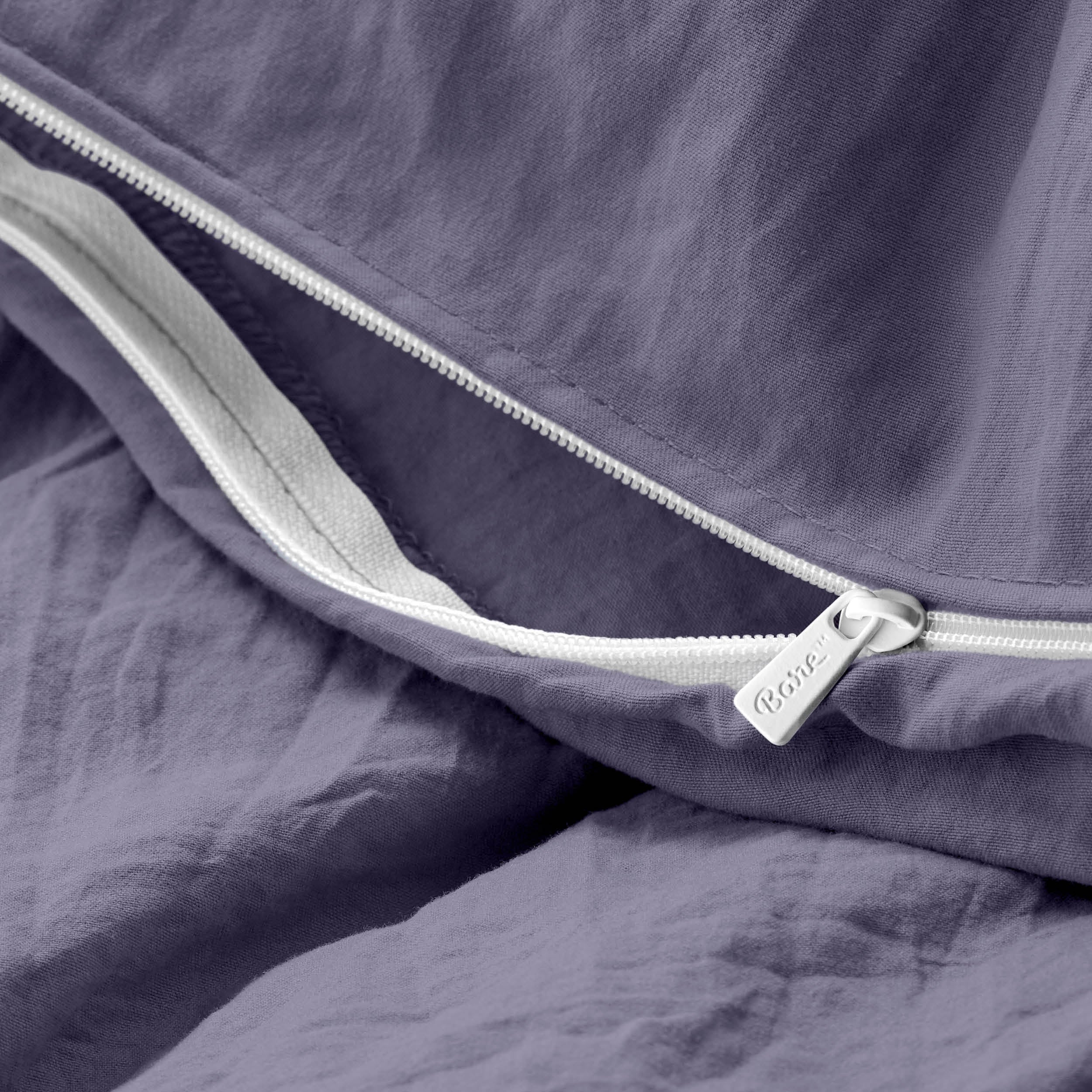 Close-up of a duvet cover with a zipper, featuring the brand Bare Home