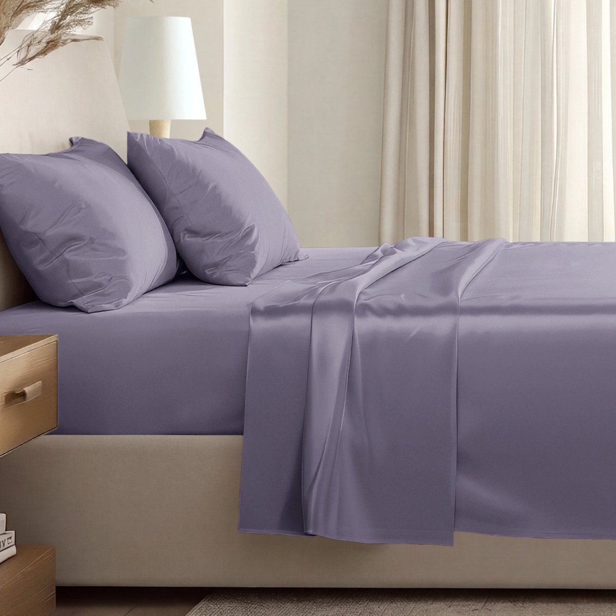 Sateen sheet set on a bed in a softly lit bedroom.