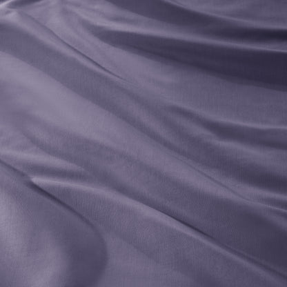 A close-up of draped sateen fabric with soft folds and a smooth texture.