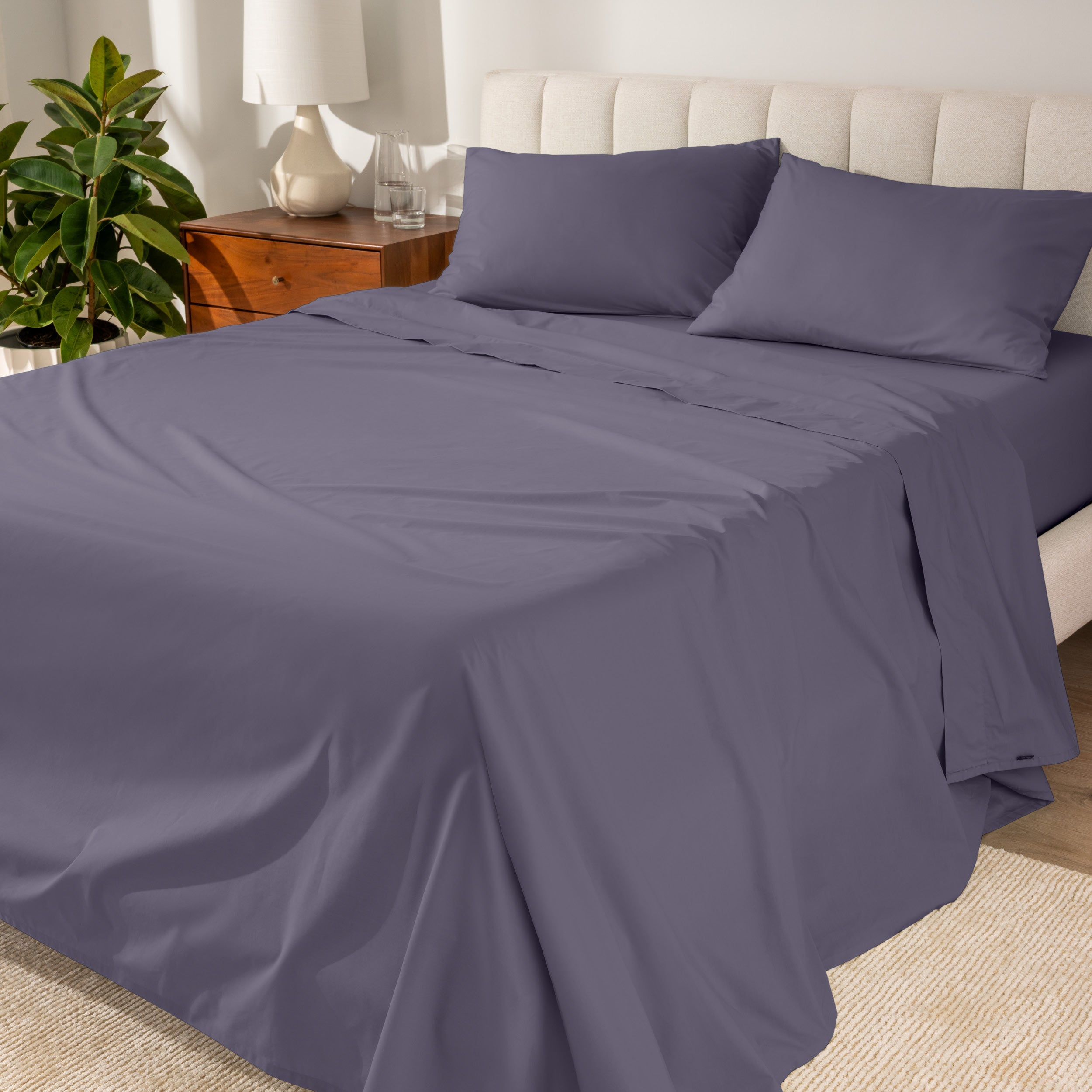 Percale sheets on a bed with a cream colored frame and headboard