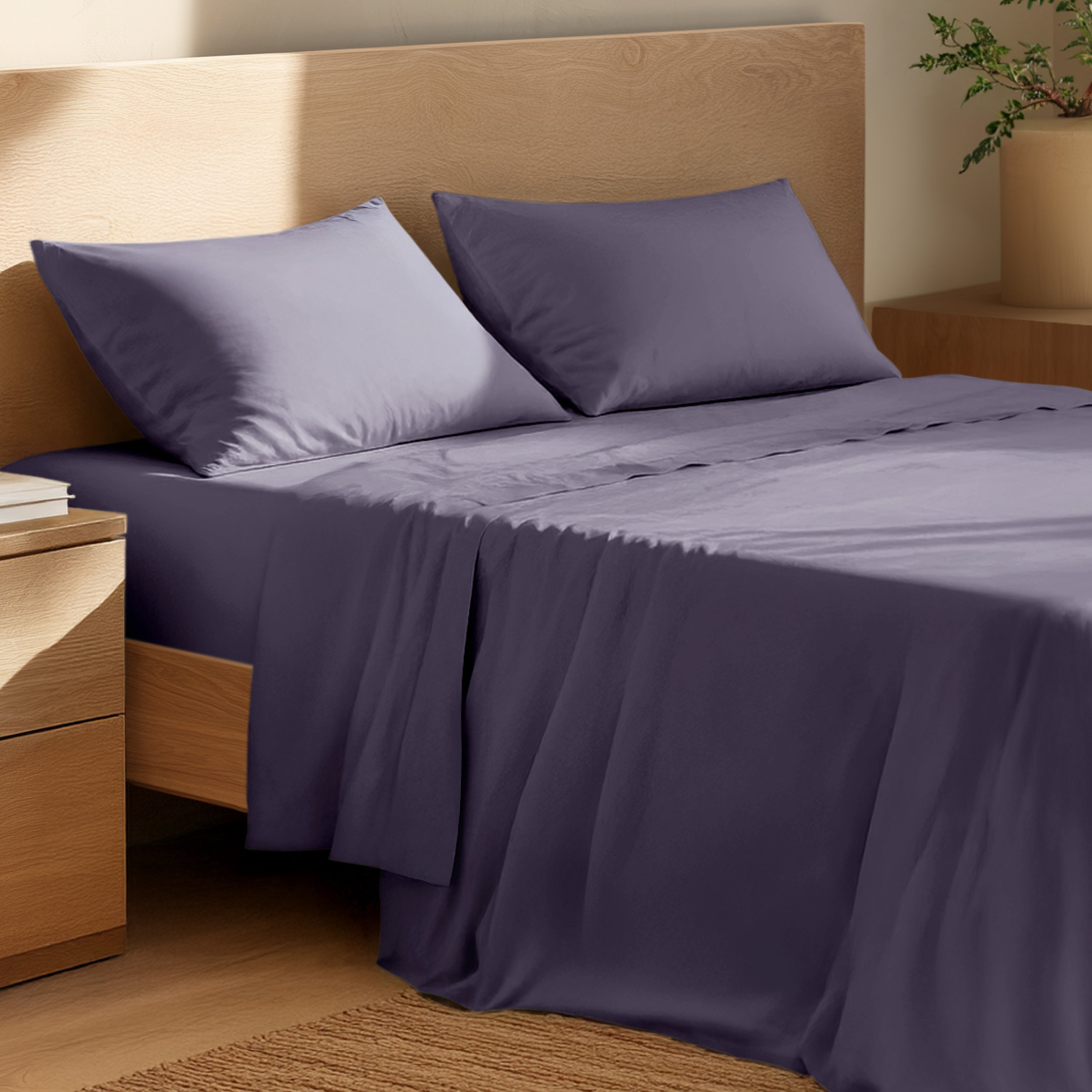 Bed with percale bedding and wooden headboard in a bedroom setting