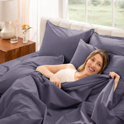 Woman lying in bed with percale bedding in a bright bedroom