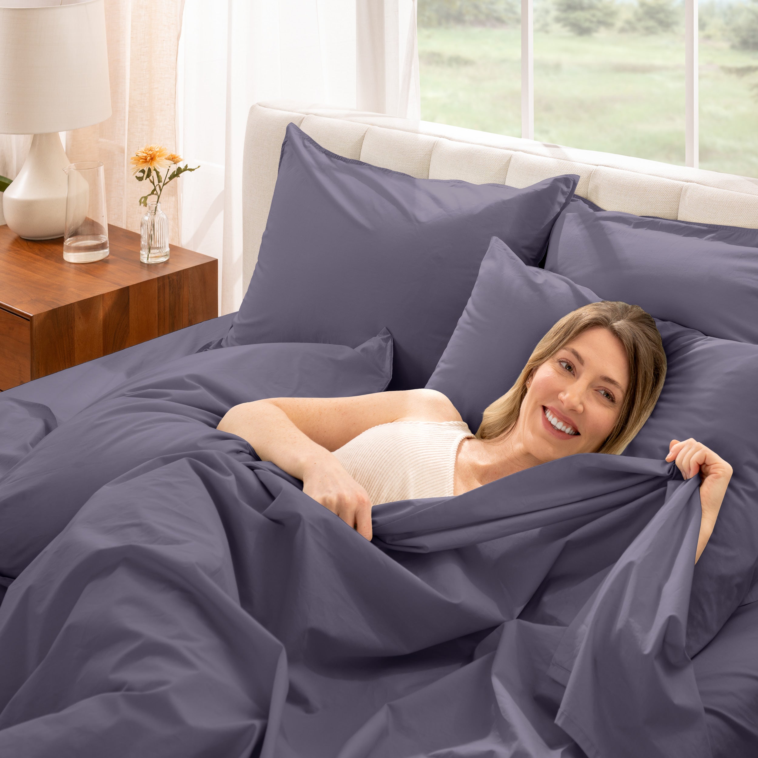 A woman is lying on a bed make with percale sheets and pillowcases