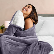 A woman smiling while wrapped in a sherpa blanket