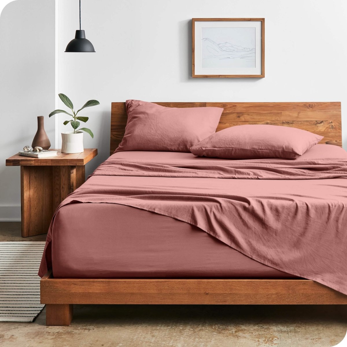 Modern bedroom with washed sheets draped over the end and the side of the bed