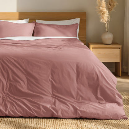 Percale bedding set on a bed with a wooden headboard and nightstand in a bedroom setting.