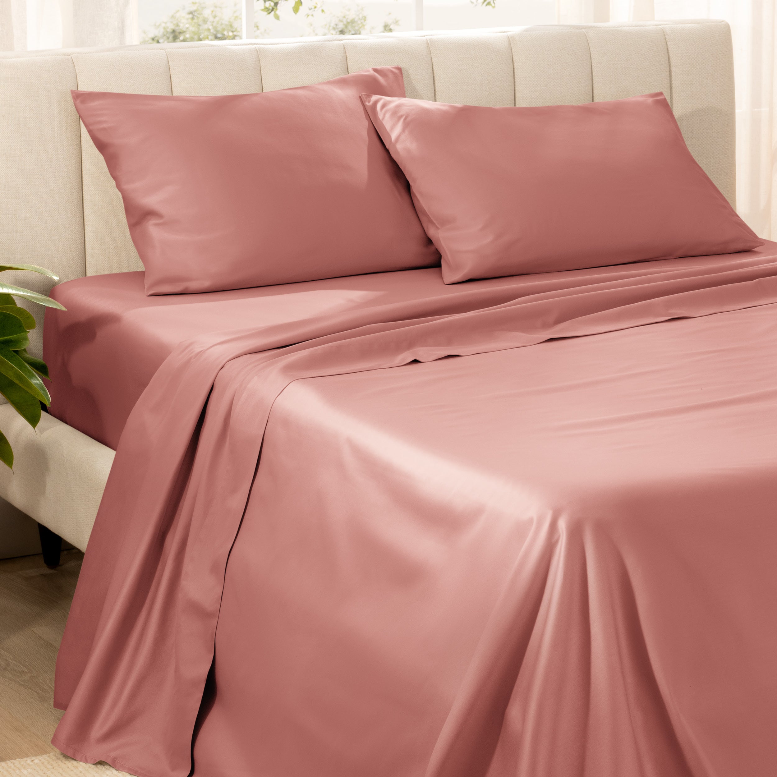 Bedding set on a bed with pillows in a bright room.