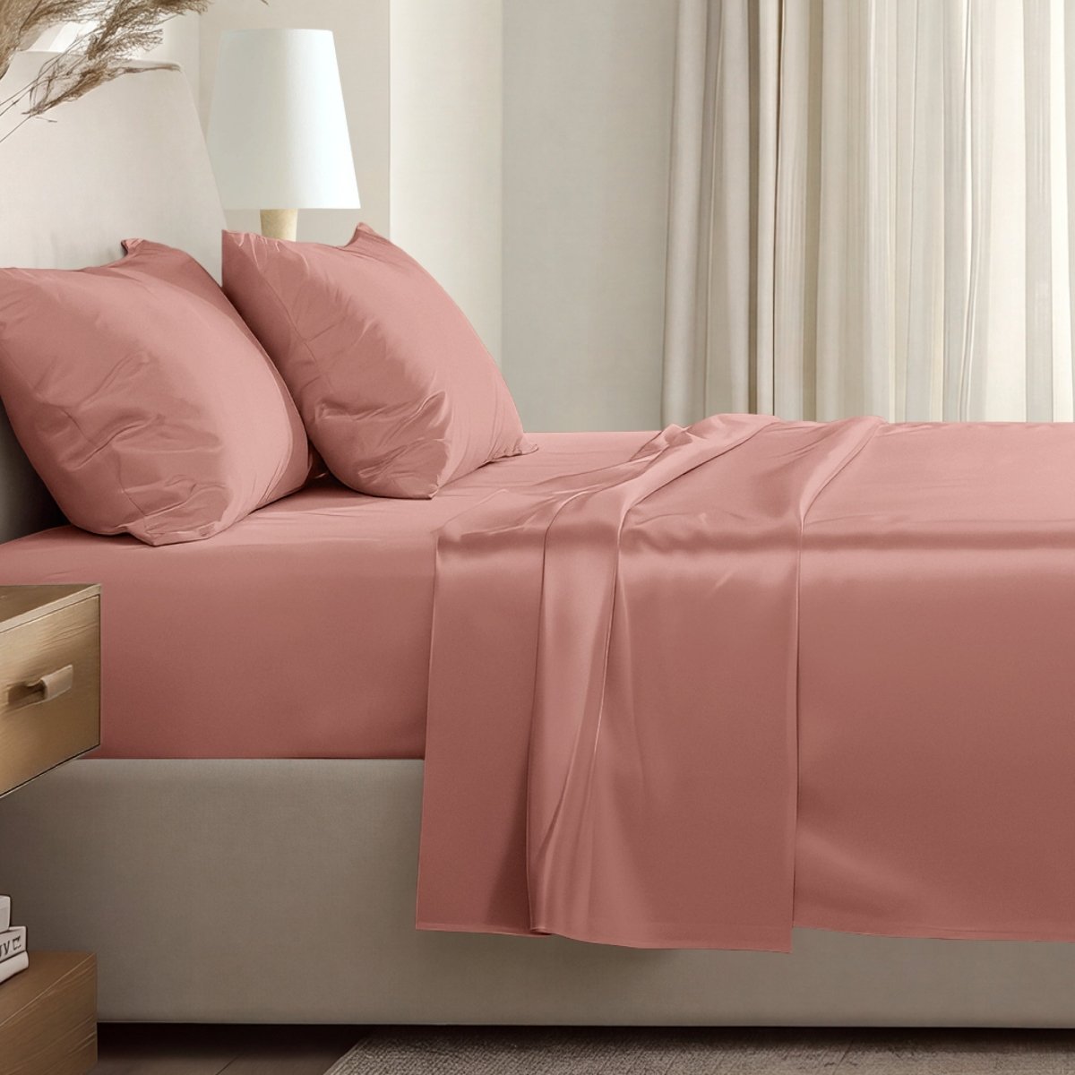 Sateen sheet set on a bed in a softly lit bedroom.
