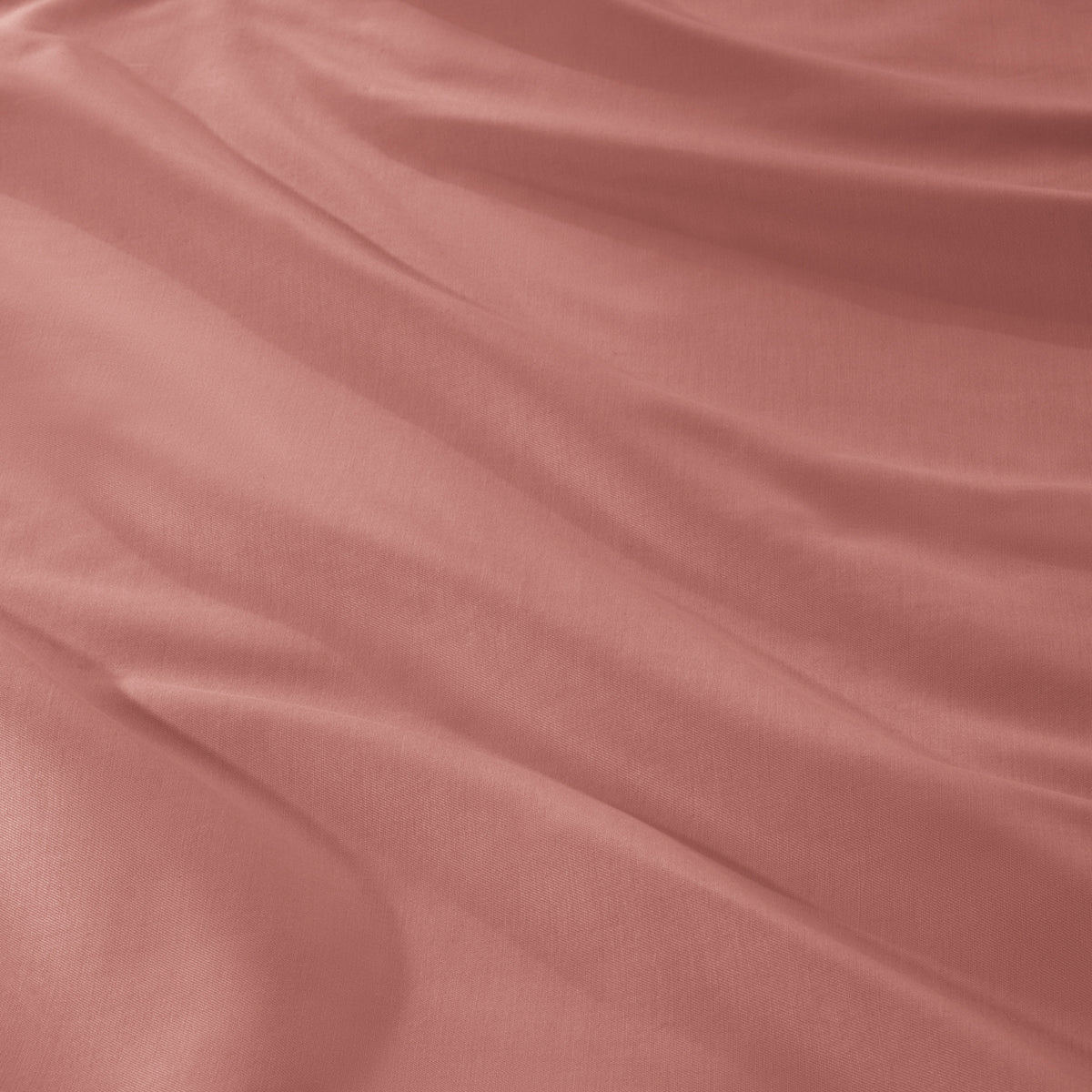 A close-up of draped sateen fabric with soft folds and a smooth texture.