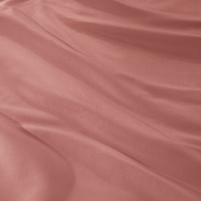 A close-up of draped sateen fabric with soft folds and a smooth texture.