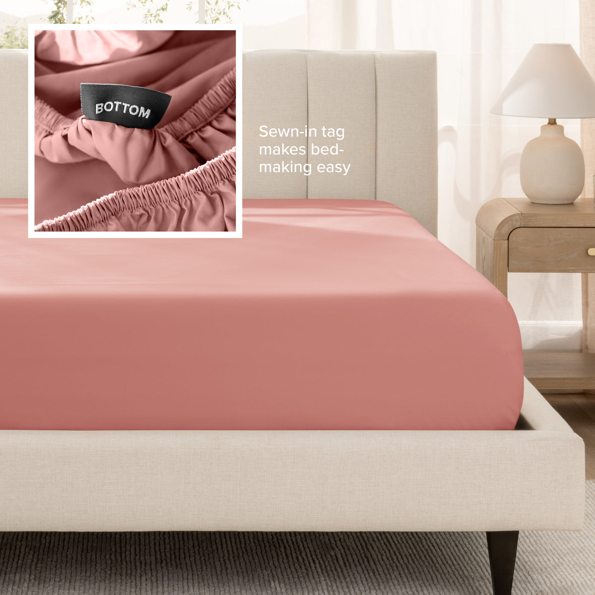 A fitted bed sheet shown on a bed. Text on the image says the sewn-in tag makes bed-making easy.