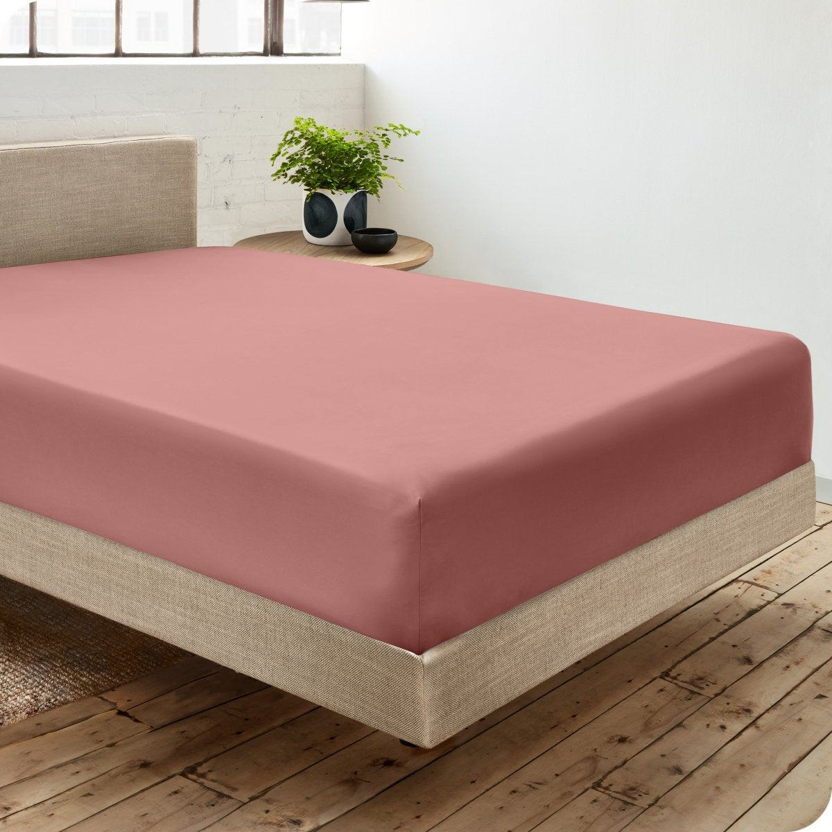 Diagonal view of room scene with percale fitted sheet on the bed