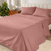 Percale sheets on a bed with a cream colored frame and headboard