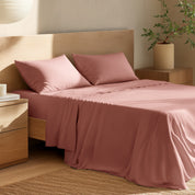 Bed with percale bedding and wooden headboard in a bedroom setting