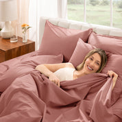 Woman lying in bed with percale bedding in a bright bedroom