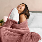 A woman smiling while wrapped in a sherpa blanket