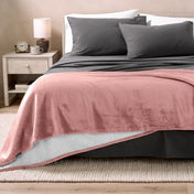 Bed with grey sheets and a sherpa blanket