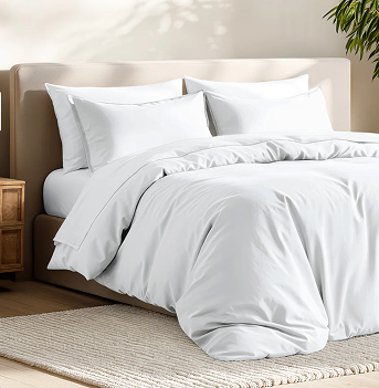 White Duvet Cover made bed in a sunny beige colored room
