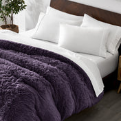 Shaggy duvet cover on a bed with white pillows and a wooden headboard.