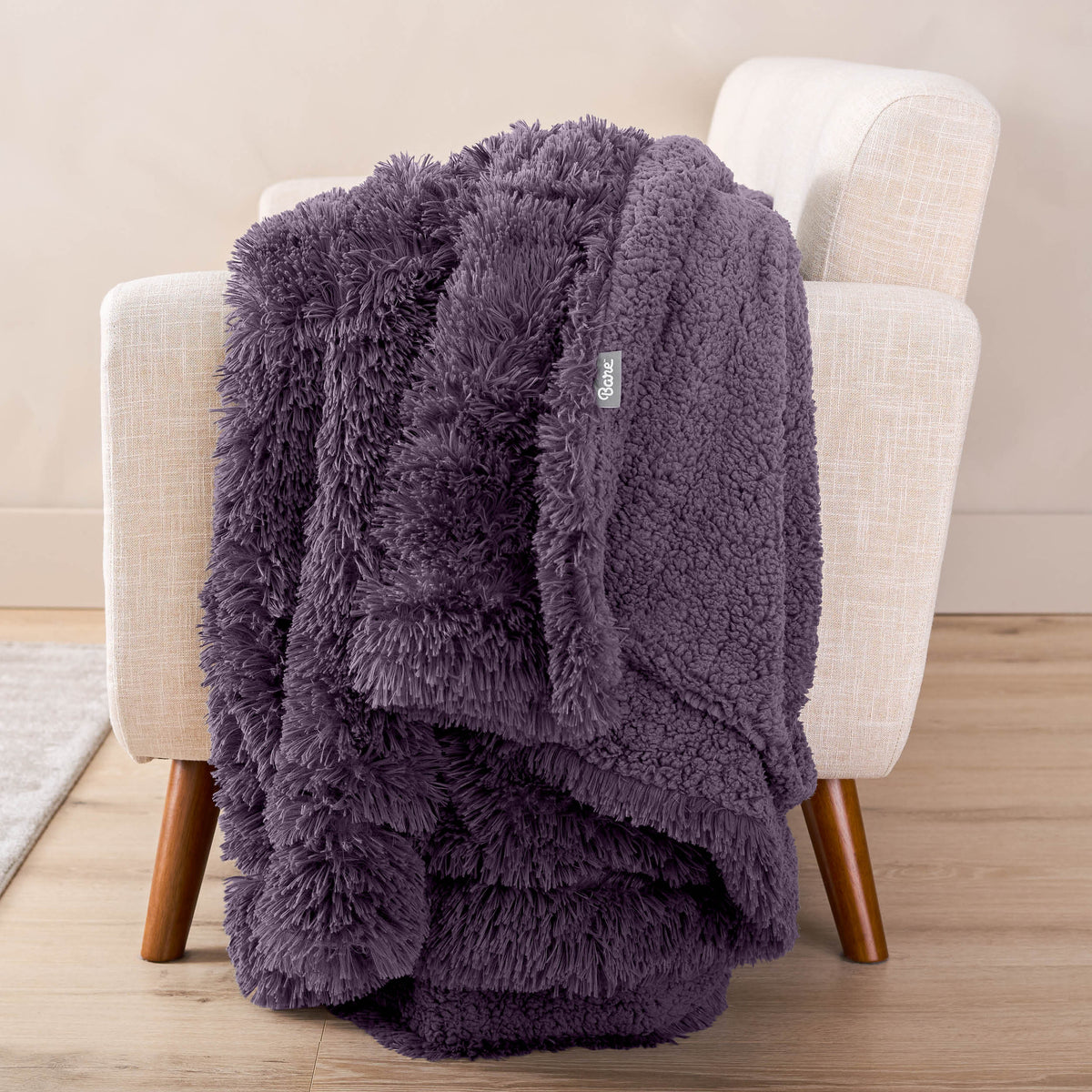 A shaggy blanket draped over the arm of a chair