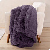 A shaggy faux fur blanket draped over the arm of a chair
