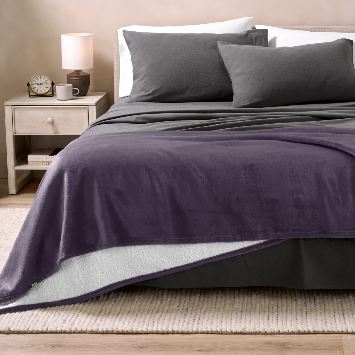 Bed with grey sheets and a sherpa blanket
