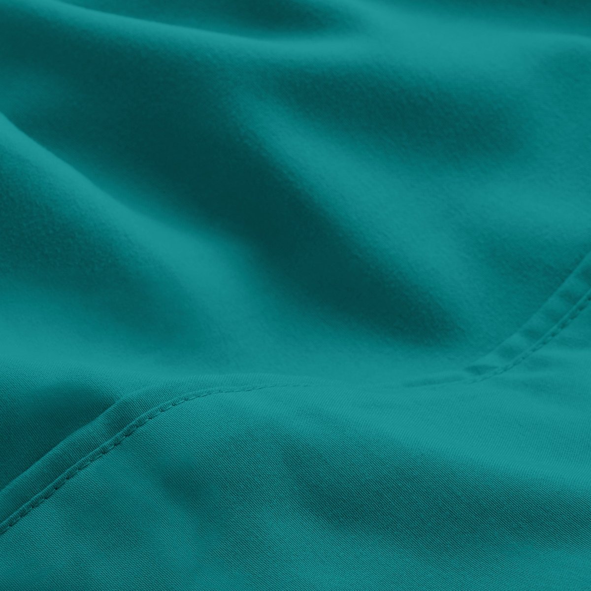 A close-up of microfiber fabric with soft folds and a visible stitched seam.
