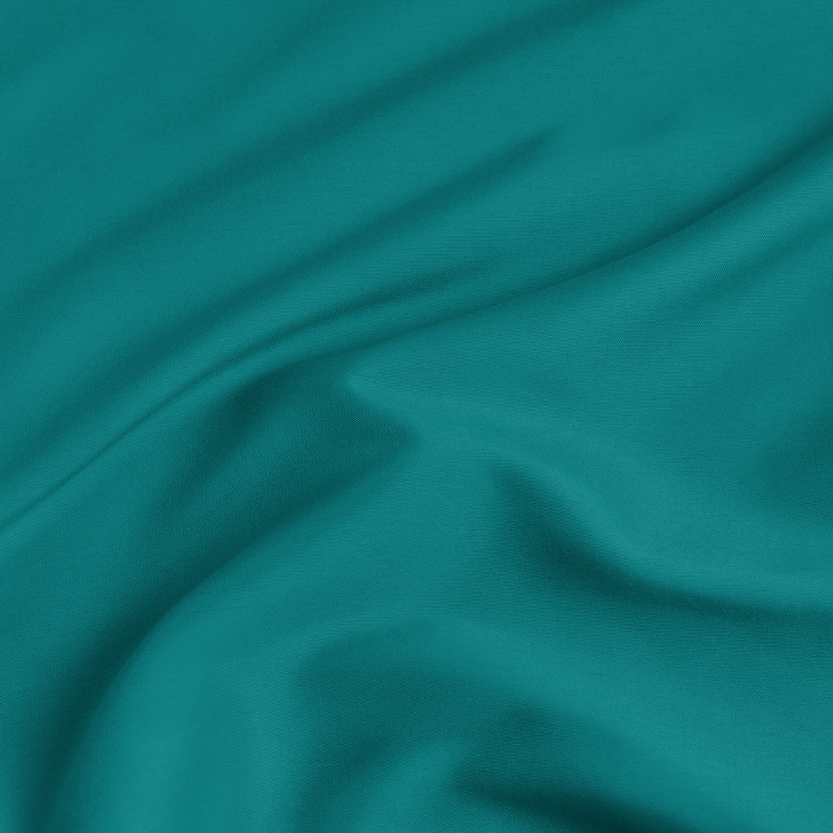 A close-up of a fitted sheet with a label printed with the word 'BOTTOM' in white.