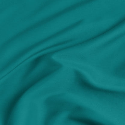 A close-up of a fitted sheet with a label printed with the word 'BOTTOM' in white.