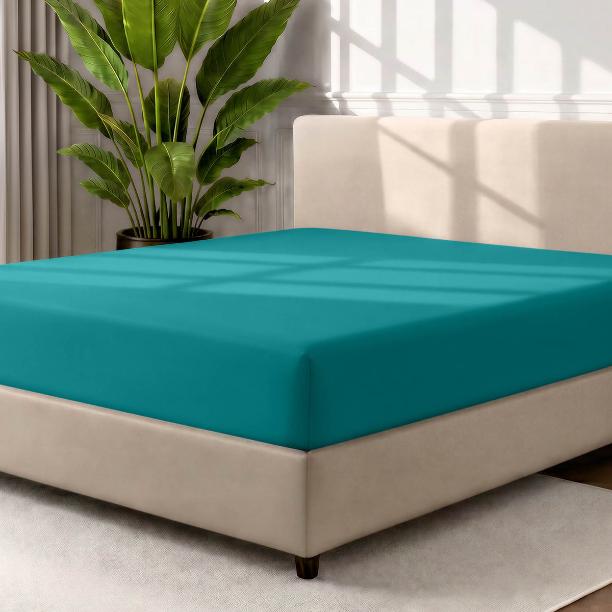 Bed with a fitted sheet in a room with a large plant and rug