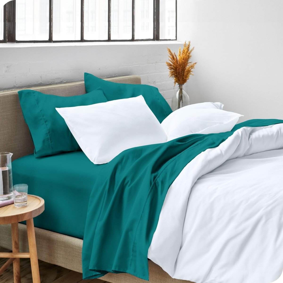 A side view of a bed made with microfiber sheets and a white duvet cover