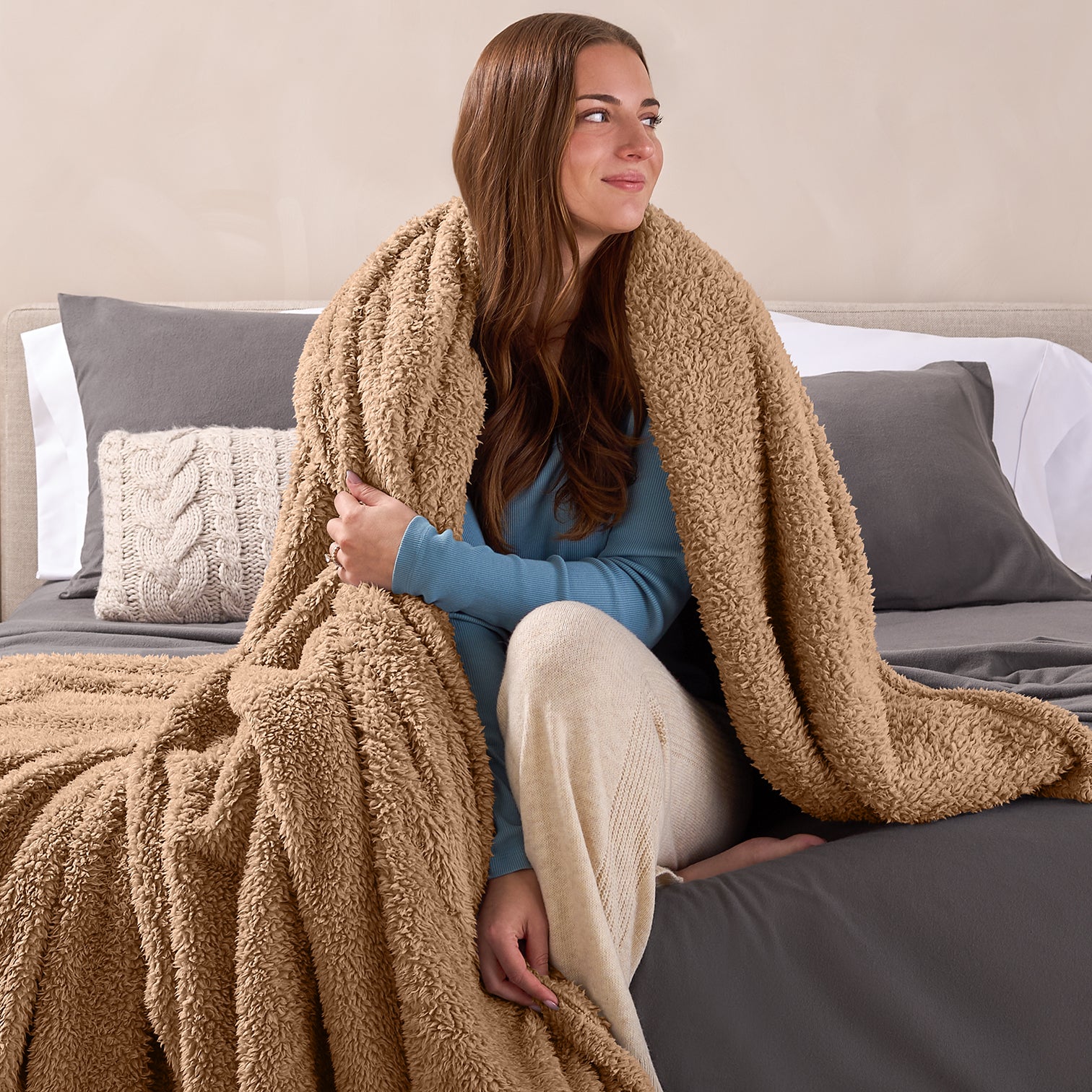 Lady Sitting On Edge of Bed with a Teddy Bear Colored Sherpa Blanket