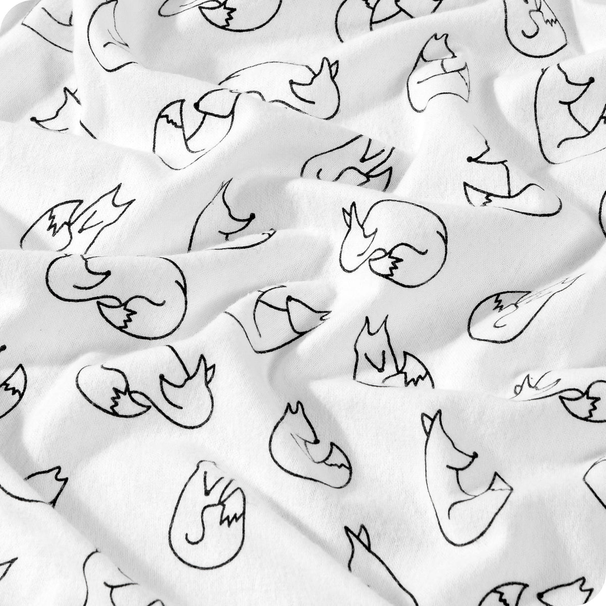 White fabric with a black line art pattern of sleeping foxes, shown in soft folds.
