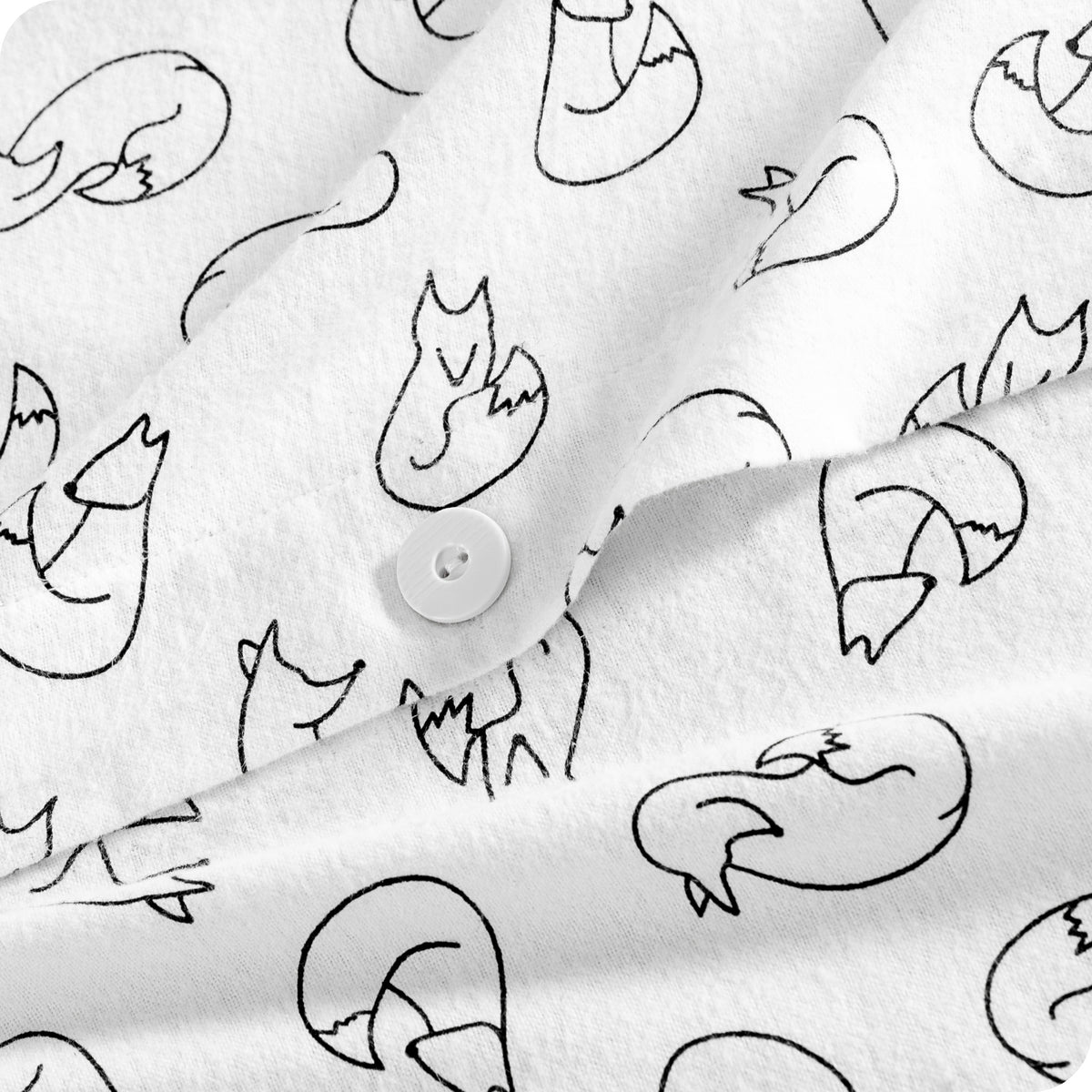 White fabric with a black line-art pattern of foxes and a white button, shown in a close-up product shot.