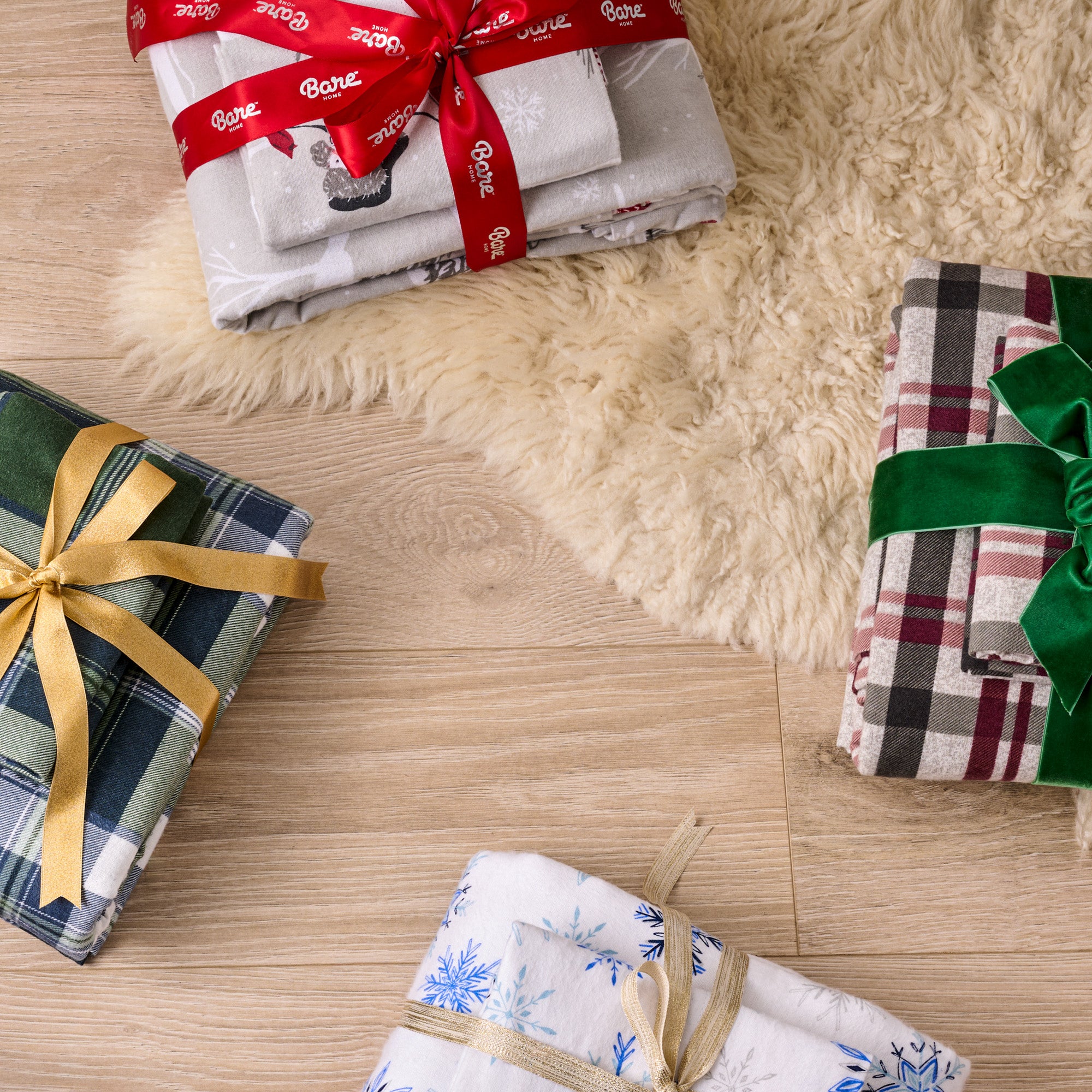 Flannel sheet sets wrapped with ribbons on a wooden surface.